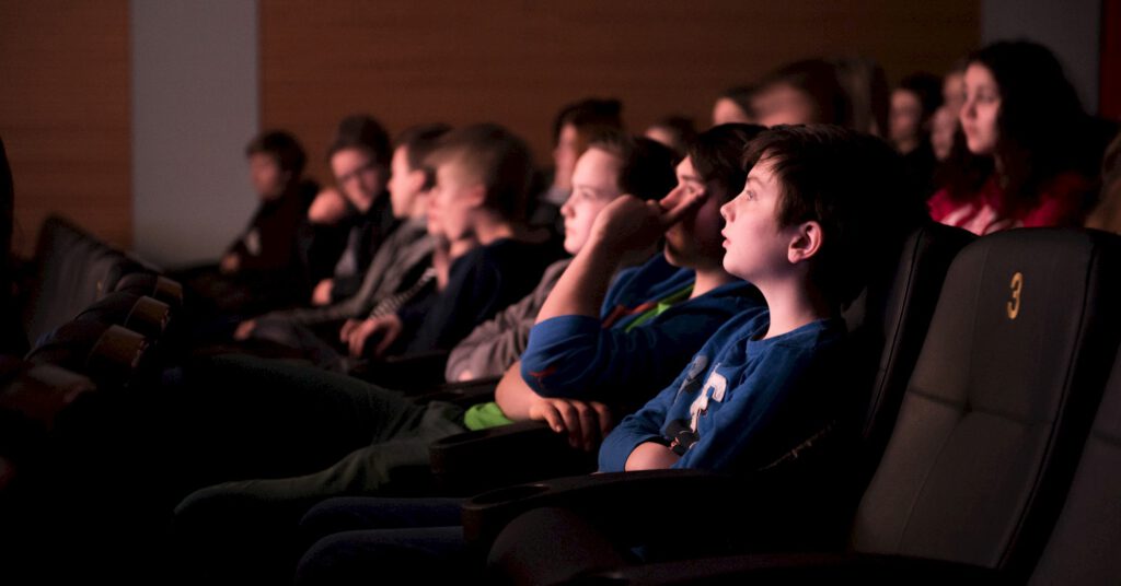 Kinder sitzen im Kino.